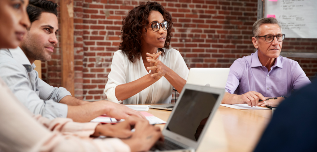 University marketing and communications team in a strategy meeting, discussing workflow optimization and cross-department collaboration during a consulting session.